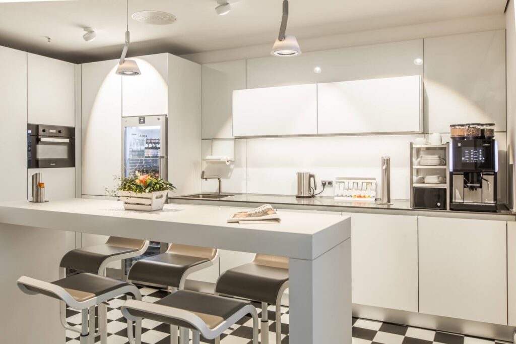 Helle, moderne Küche mit Kaffeemaschine, Kühlschrank und Tresen zum Sitzen im Lüneburg Kontor