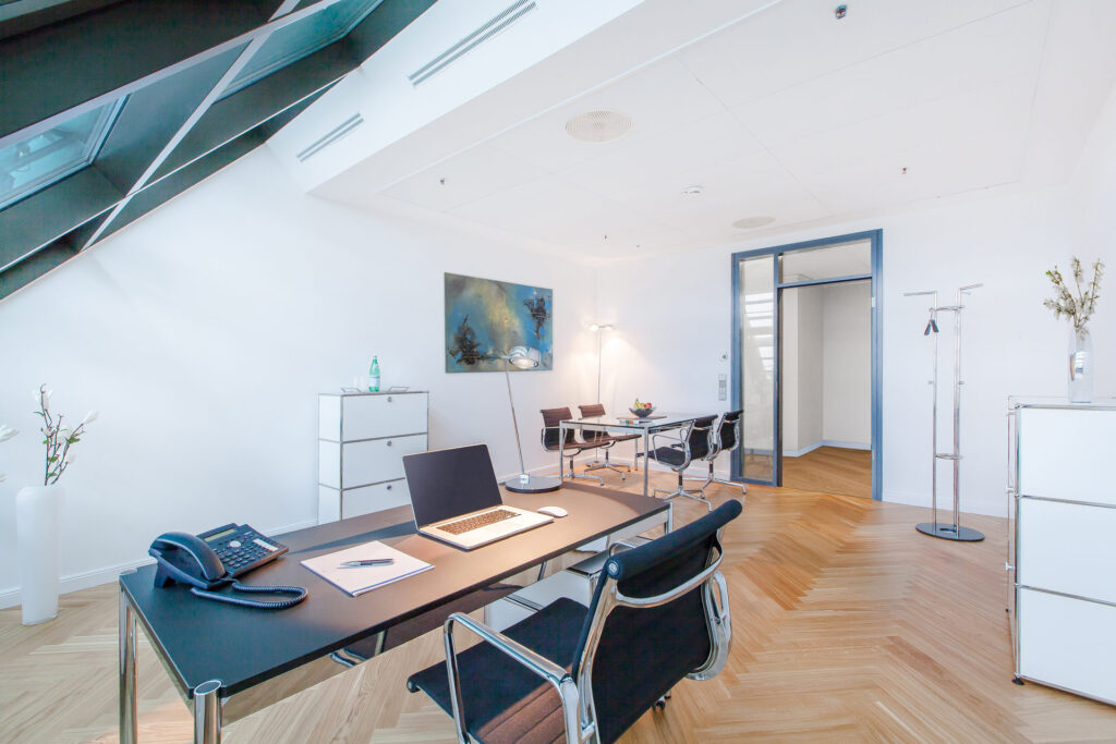 Ein helles, modern eingerichtetes Büro mit Schreibtisch und Besprechungstisch zum Mieten im Lüneburg Kontor
